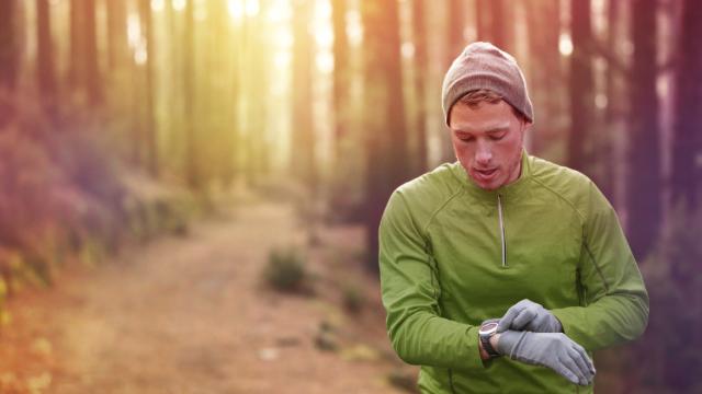 Man checking his smartwatch on a frosty morning while out for a run