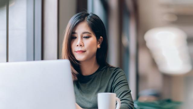 Portrait of Young Smart Asian Woman Freelance Online Working from Home with Laptop at Home Living Room in Coronavirus or Covid-19 Outbreak Situation