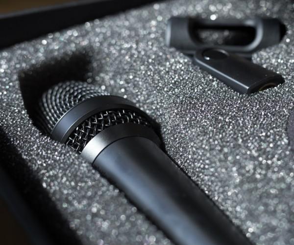 Black microphone and earpiece in a padded box