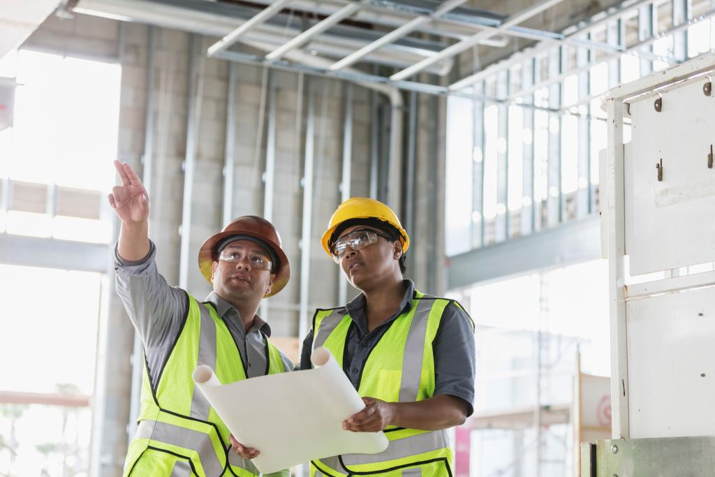 two construction workers pointing