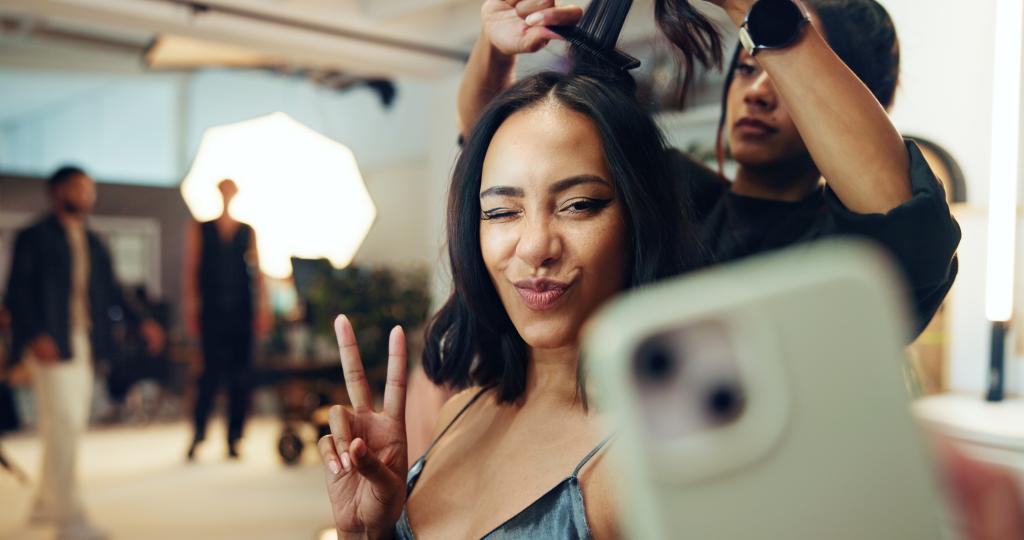 women holding a light teal phone to take a selfie