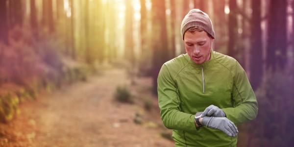 Man checking his smartwatch on a frosty morning while out for a run
