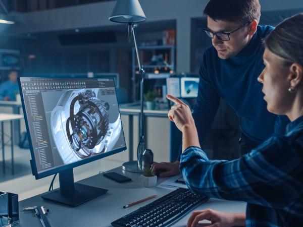 Engineer Working on Desktop Computer, Screen Showing CAD Software with Engine 3D Model