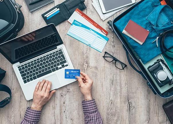 Man using credit card to pay online representing the use of online booking tools for business travel.