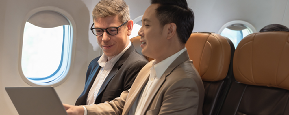 Two men looking at a laptop screen representing meaningful ways to engage with Youth Day.