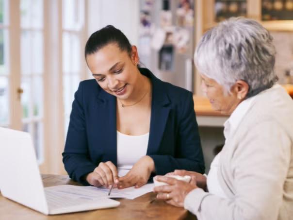 A travel professional advising an elderly woman representing smart ways to reduce business travel costs.