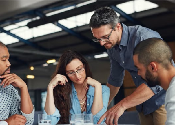 Co-workers reviewing a presentation demonstrating how a travel policy can set up your 2025 business travel up for success.