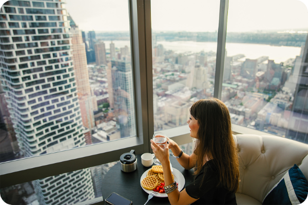 woman sitting inside a hotel looking out