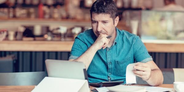 Man checking expense receipts with ipad