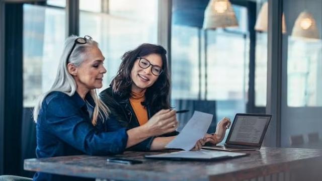 Two women sitting in an office in discussion demonstrating the importance of choosing the best insurance with a travel expert.