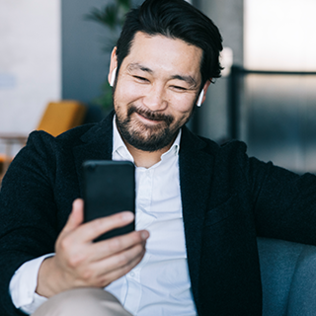 Man sitting on lounge looking at phone.