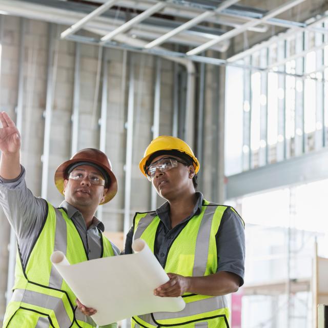 two construction workers pointing