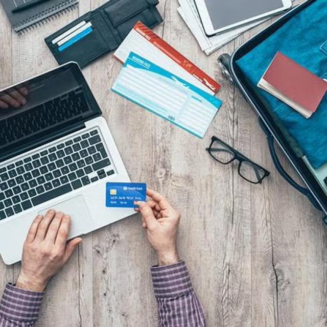 Man using credit card to pay online representing the use of online booking tools for business travel.
