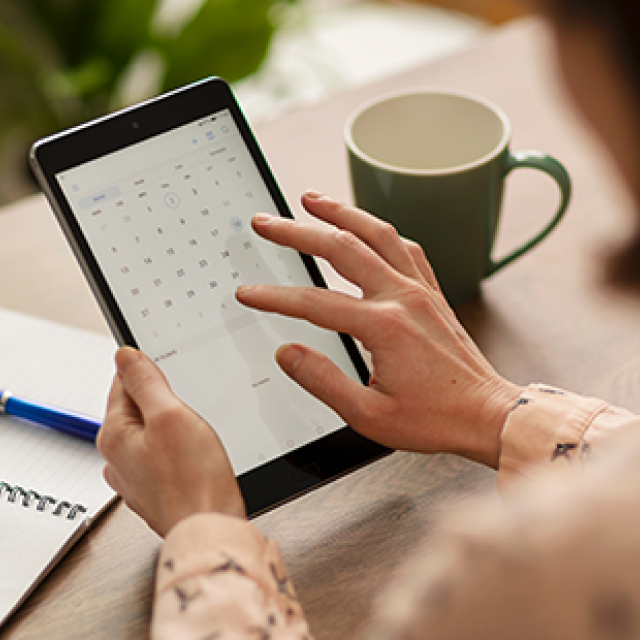 woman scrolling through calender on a tablet 